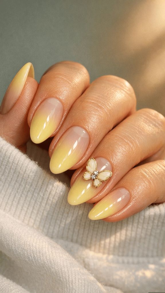 Almond nails with yellow ombré and gold butterfly nail charm