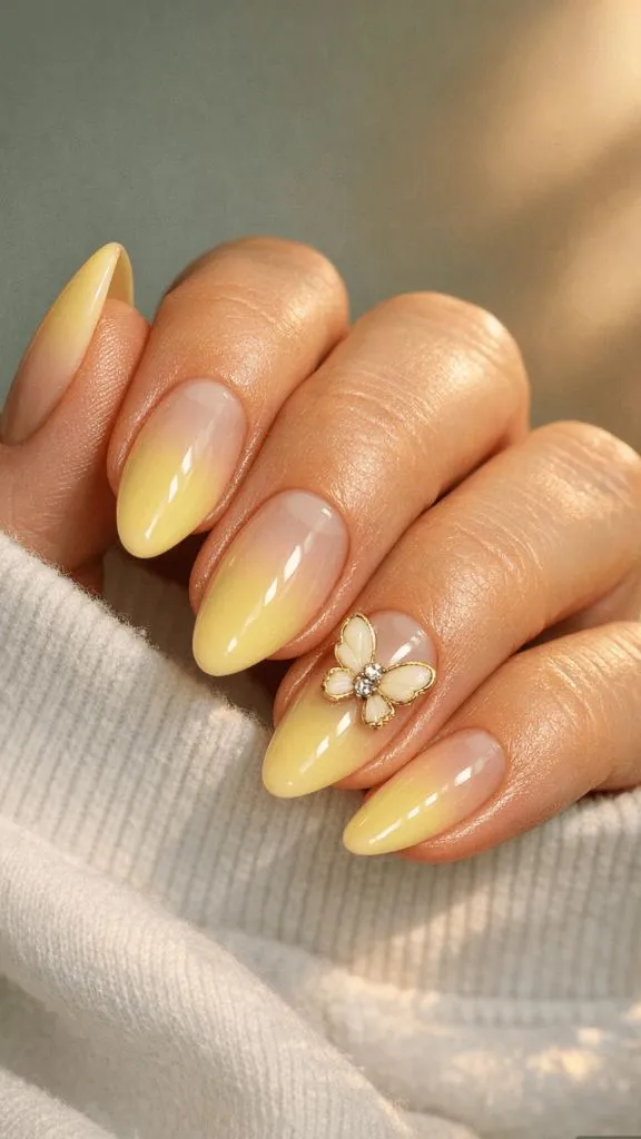 Almond nails with yellow ombré and gold butterfly nail charm