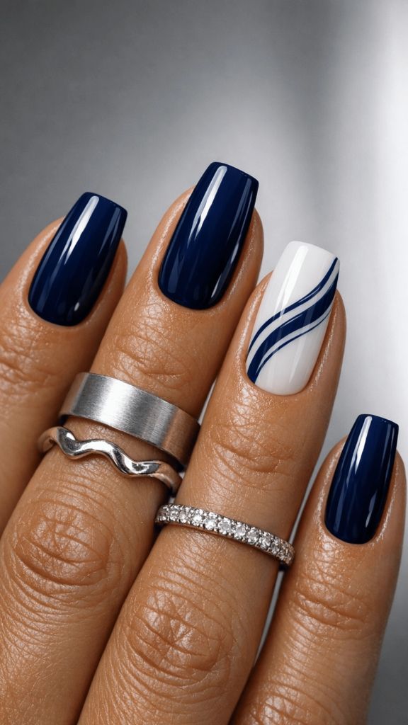 Navy blue square nails with one white accent nail featuring flowing navy wave lines