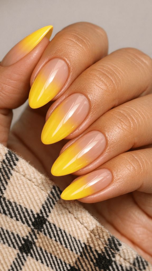 Almond-shaped nails with a nude-to-yellow gradient ombré effect