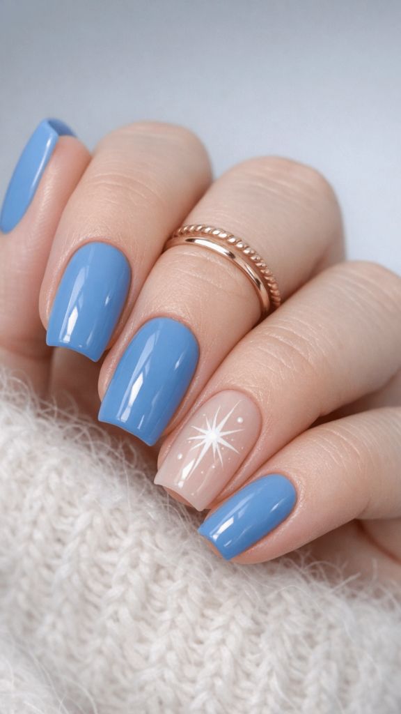 Cornflower blue nails with one nude accent nail featuring a white starburst design