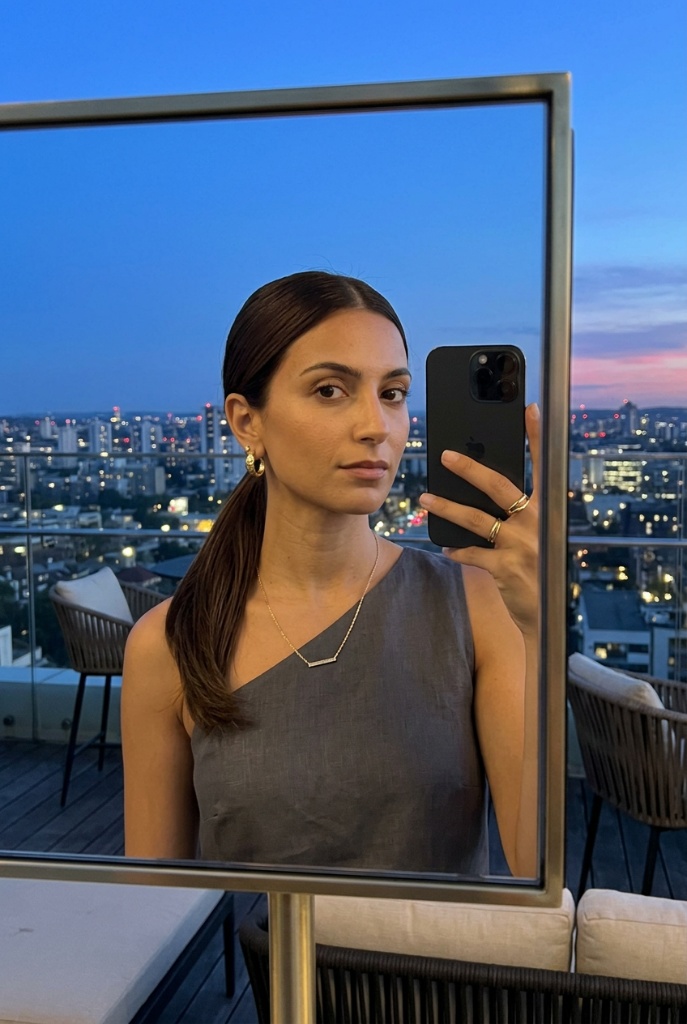 Sleek architectural high ponytail, mirror selfie with city skyline at dusk, minimalist chic rooftop style