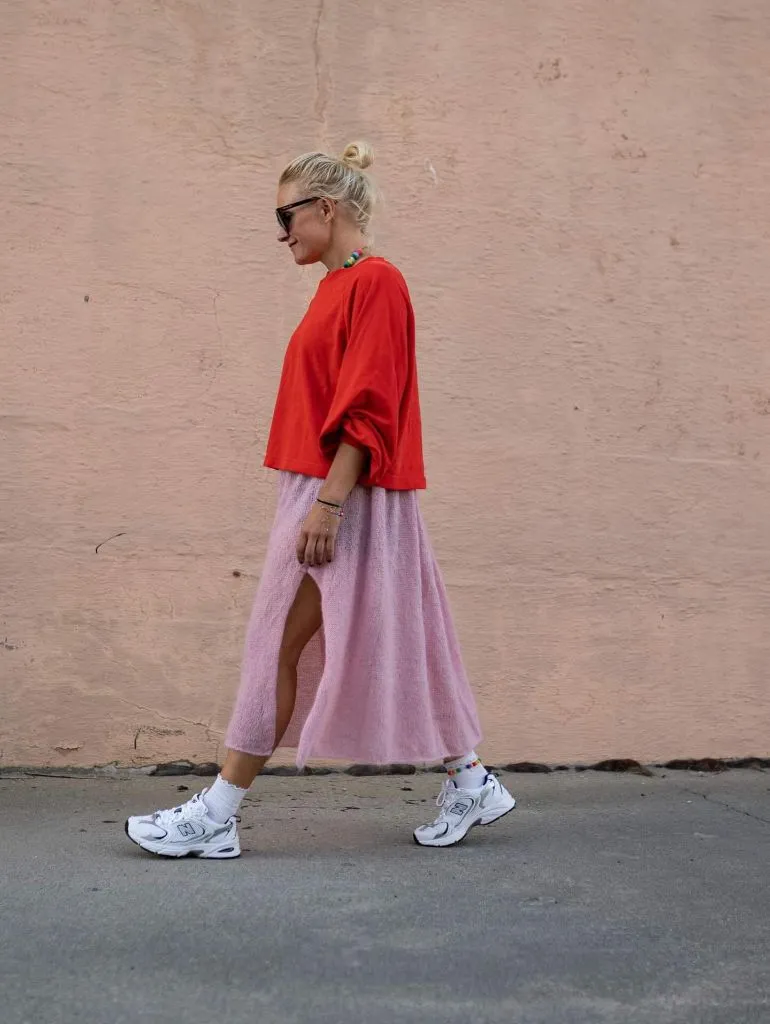 Red oversized t-shirt with pink fuzzy midi skirt and white New Balance sneakers