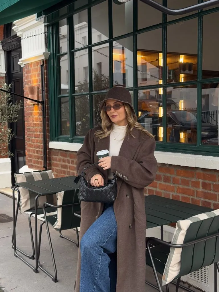 Brown coat with bucket hat and coffee