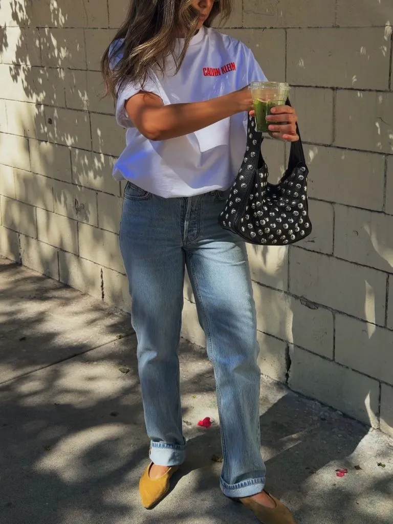 Calvin Klein white tee with light jeans and studded bag