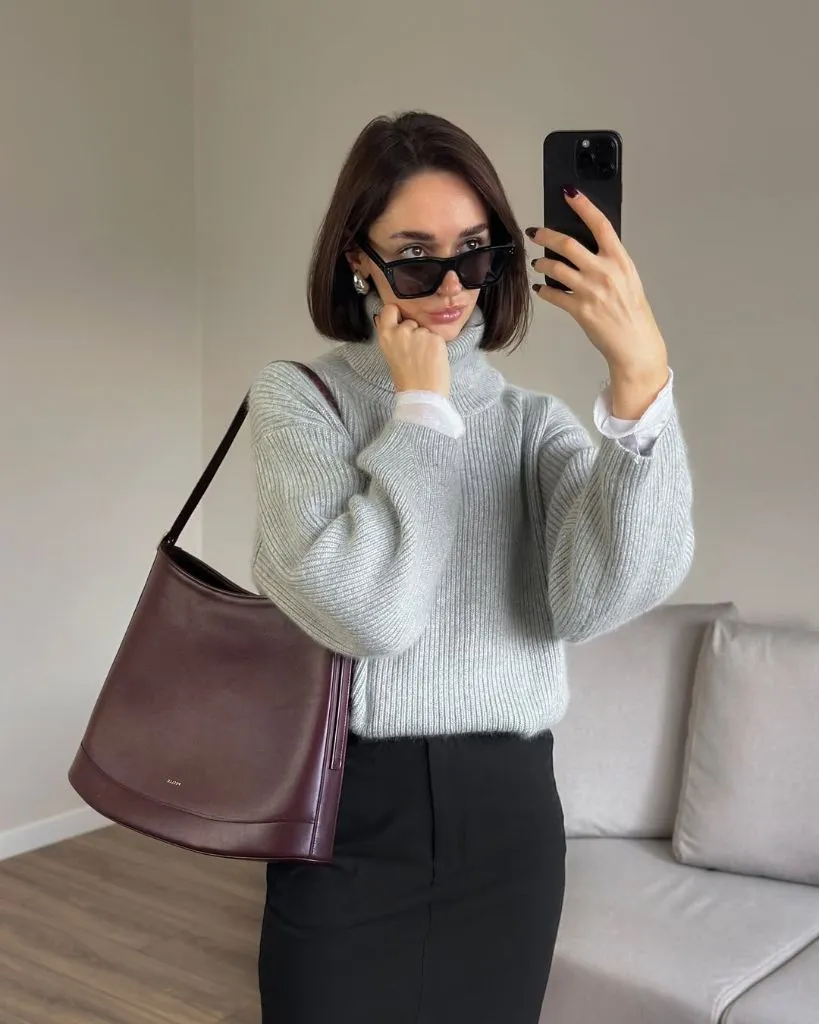 Grey ribbed turtleneck with black skirt and burgundy shoulder bag