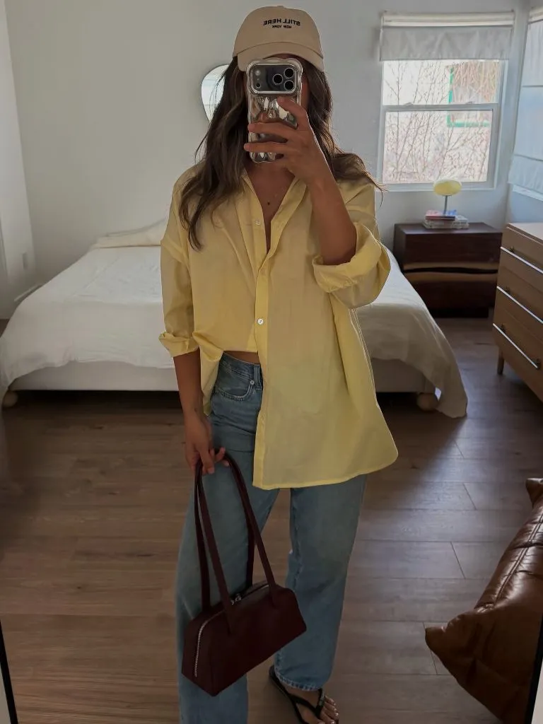 Yellow oversized button-down with jeans and baseball cap