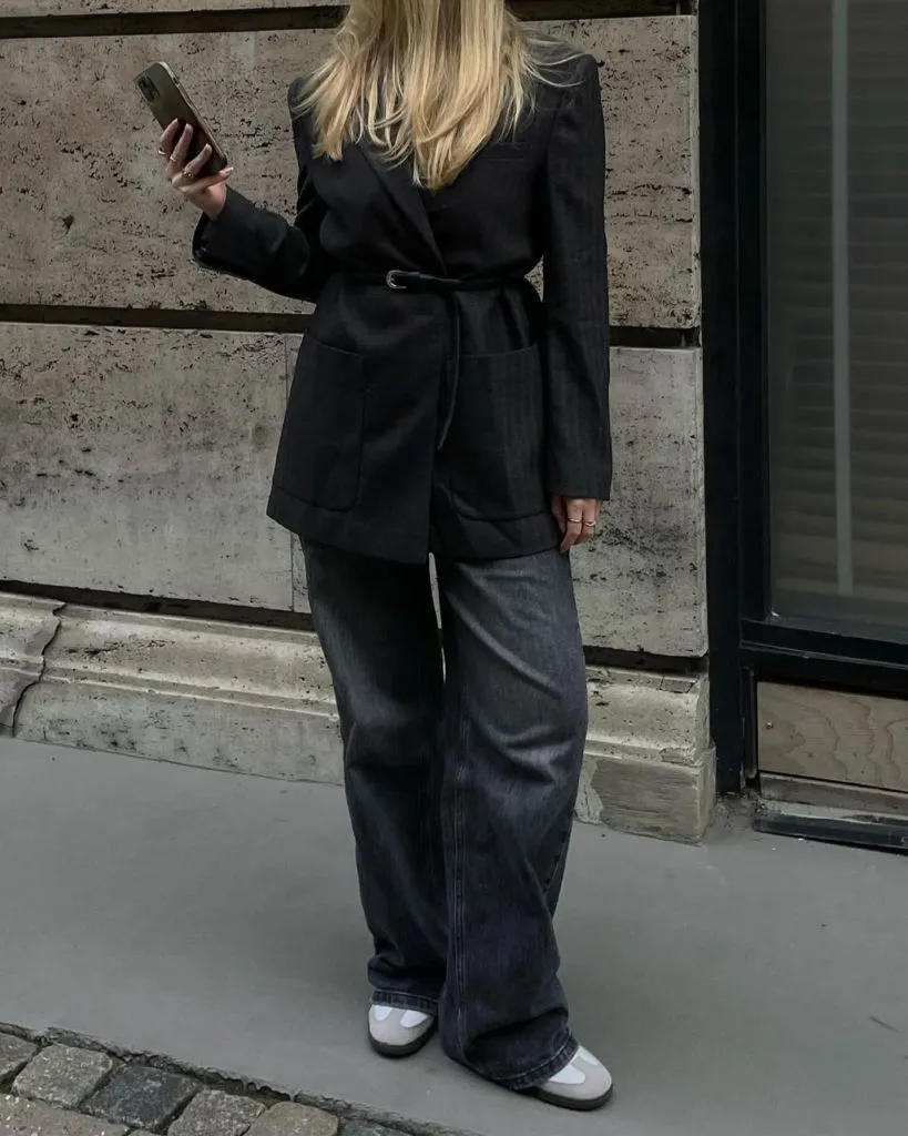 Dark belted blazer with wide-leg dark wash jeans and white ballet flats