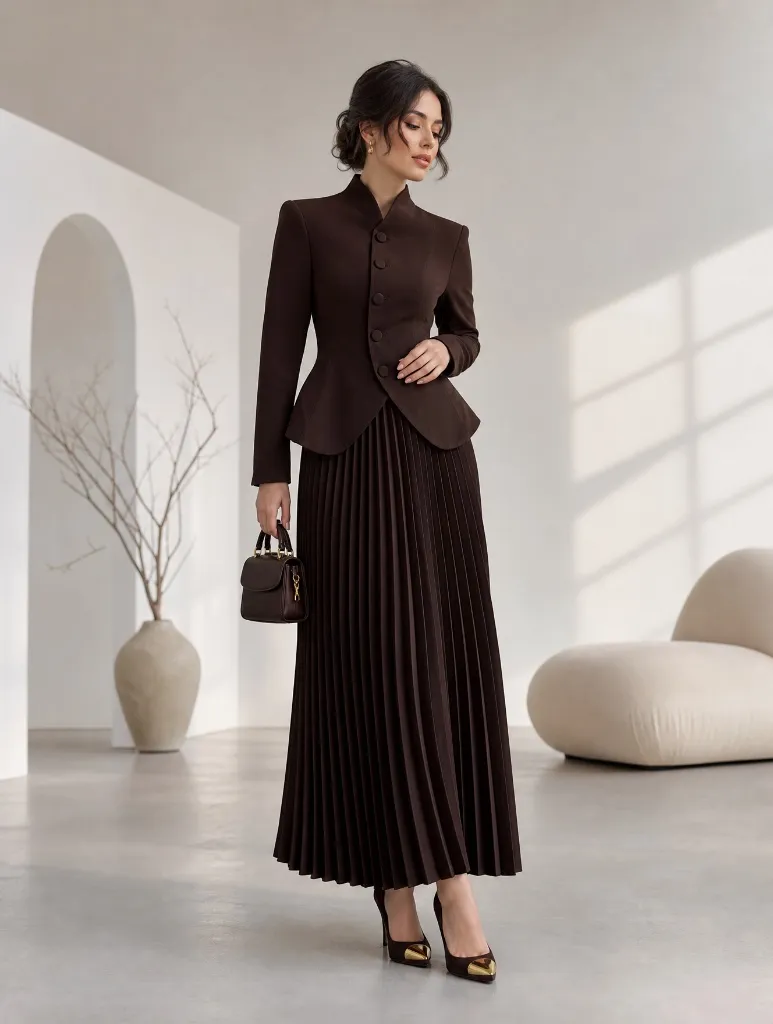 Dark brown fitted blazer with mandarin collar and chocolate pleated maxi skirt with small structured bag