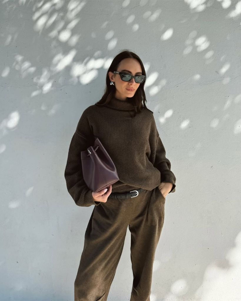 Dark brown turtleneck sweater with olive trousers and burgundy clutch