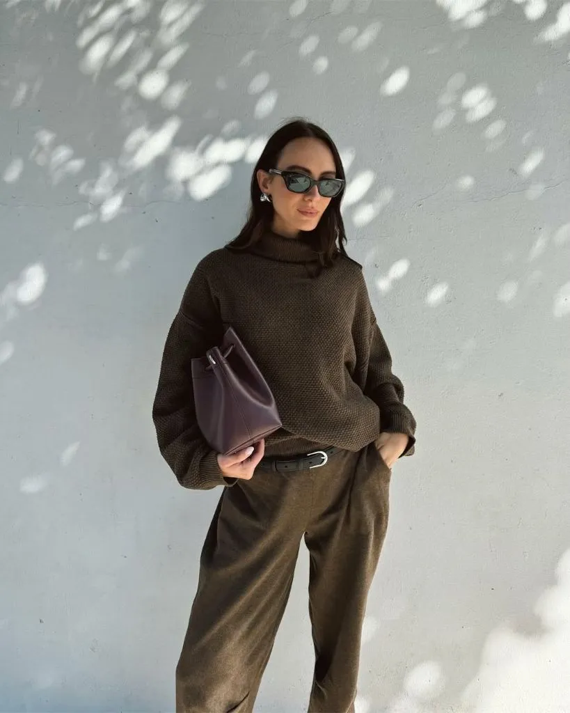Dark brown turtleneck sweater with olive trousers and burgundy clutch