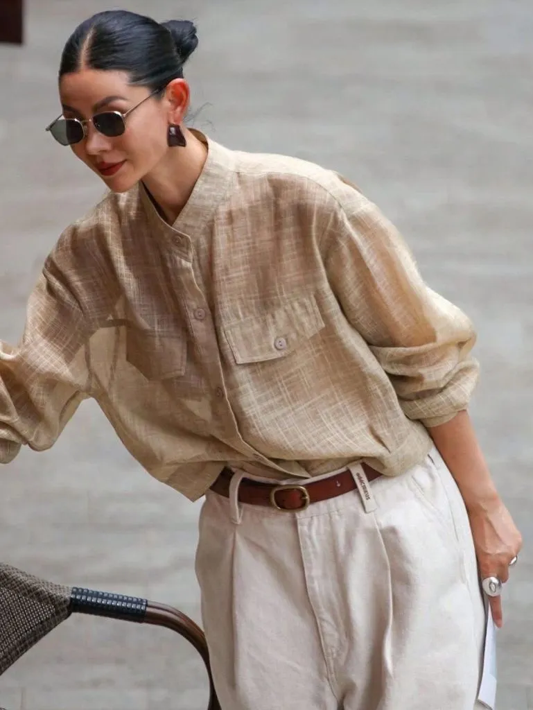 Tan linen button-down shirt with cream pleated trousers and brown leather belt
