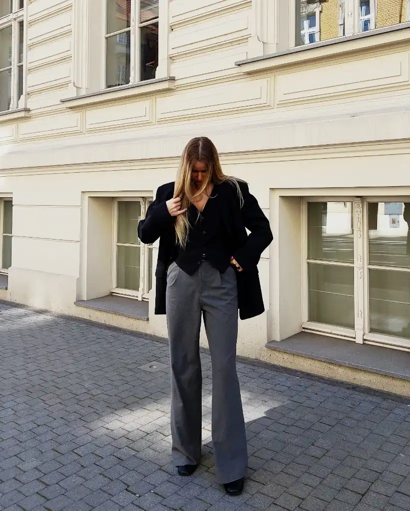 Black blazer with grey wide-leg trousers on a European street