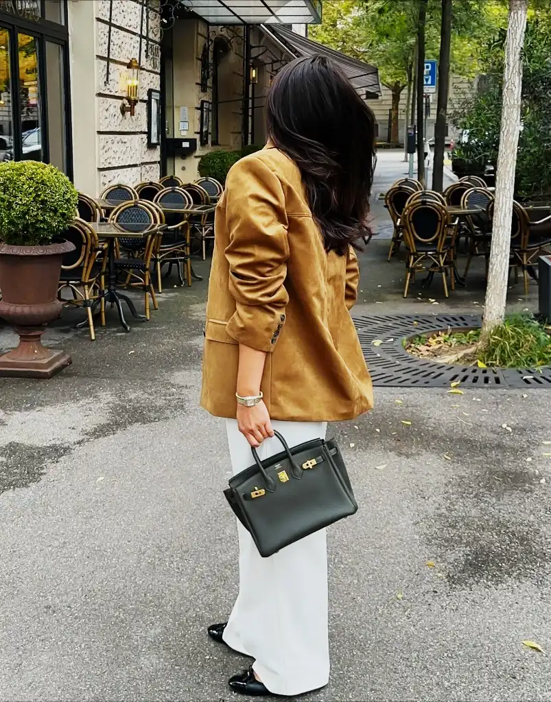 Tan suede blazer with white wide-leg trousers and black Hermès Birkin