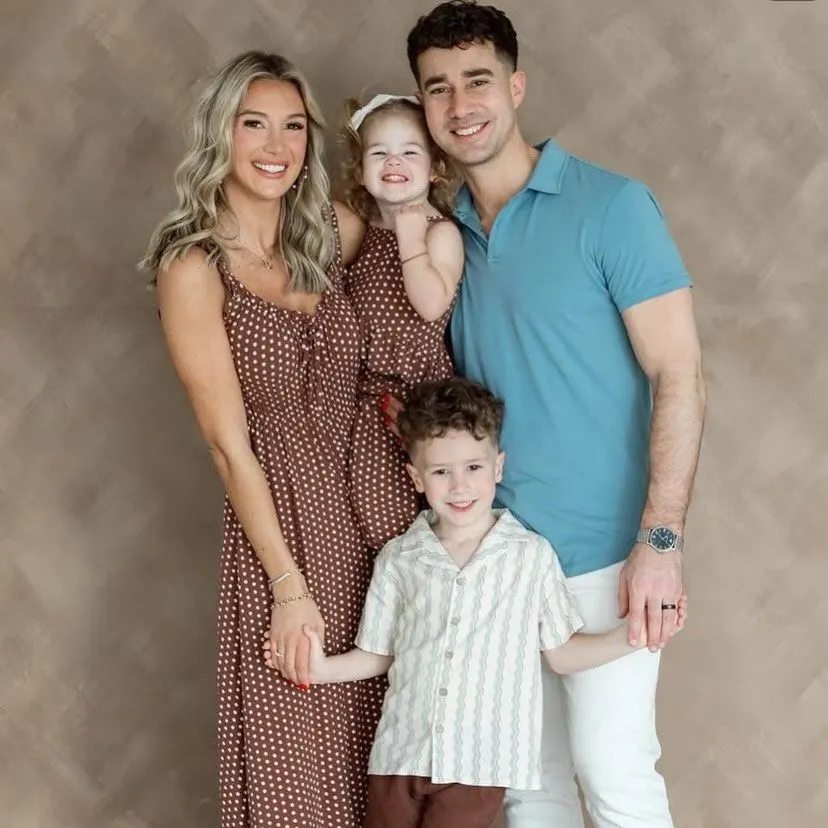 Family of four in studio with polka dot dress and pastel polo