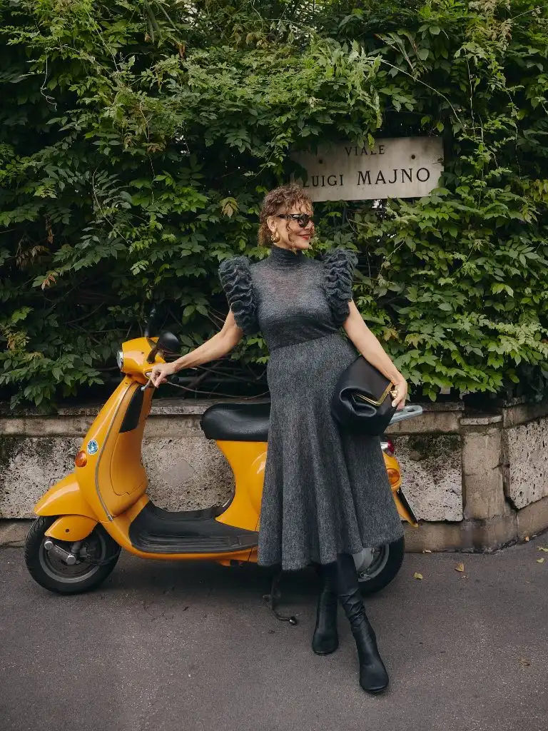 Gray puff-sleeve knit midi dress with black boots and black clutch