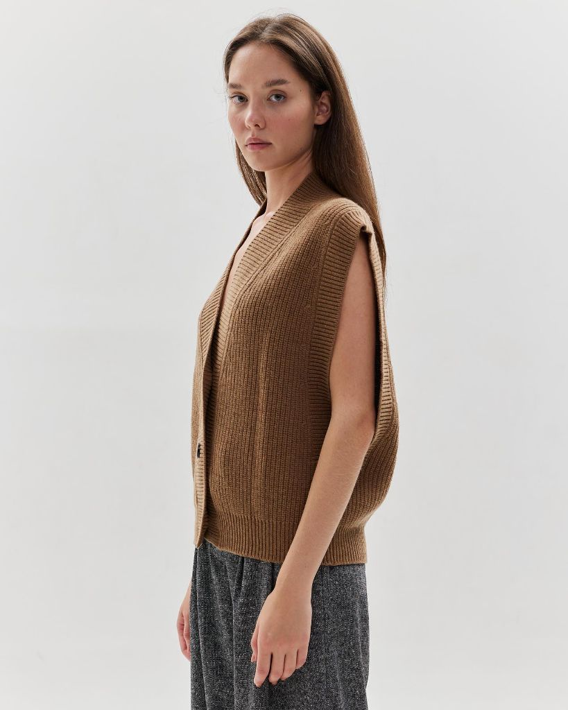 Camel-colored ribbed knit open-front vest with grey tweed-style trousers