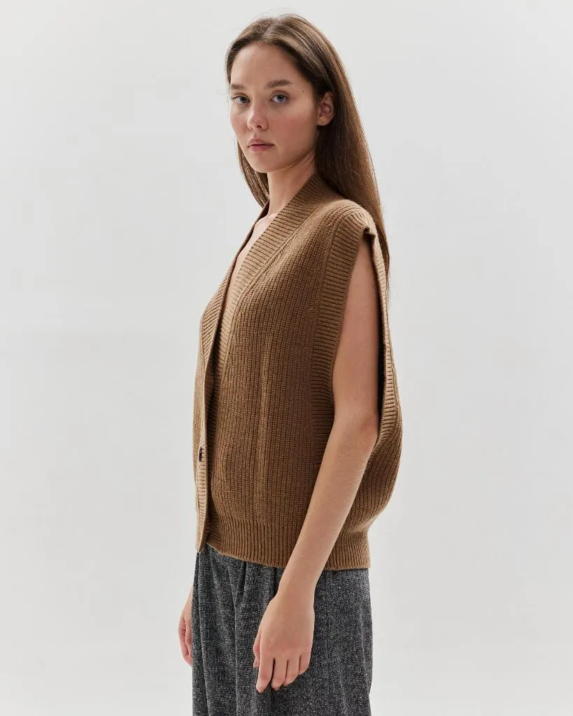 Camel-colored ribbed knit open-front vest with grey tweed-style trousers