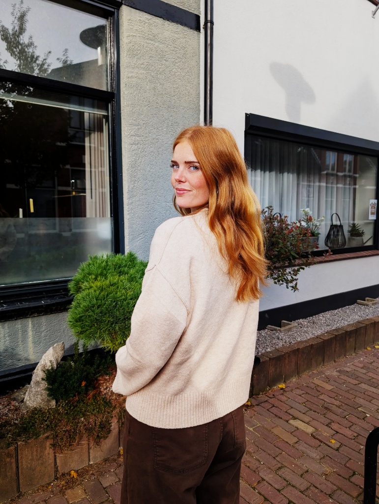 Cream oversized sweater with brown trousers, back view, red hair