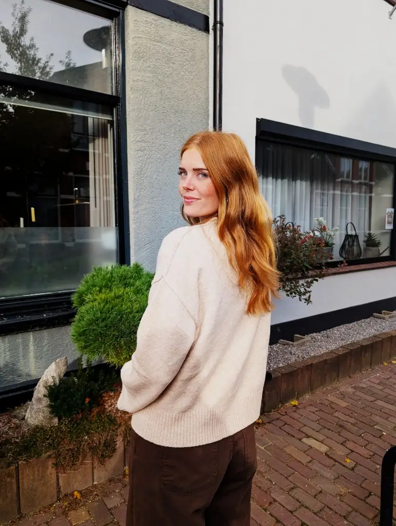 Cream oversized sweater with brown trousers, back view, red hair