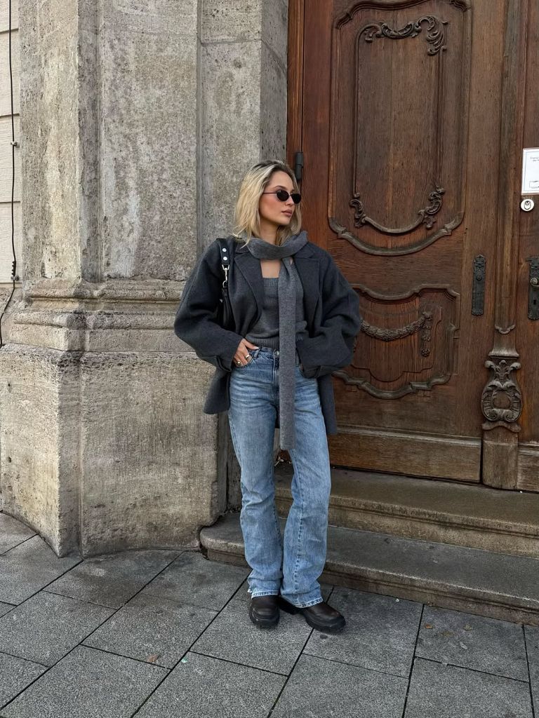 Charcoal grey oversized wool jacket with cashmere scarf, light-wash jeans, and chunky black boots
