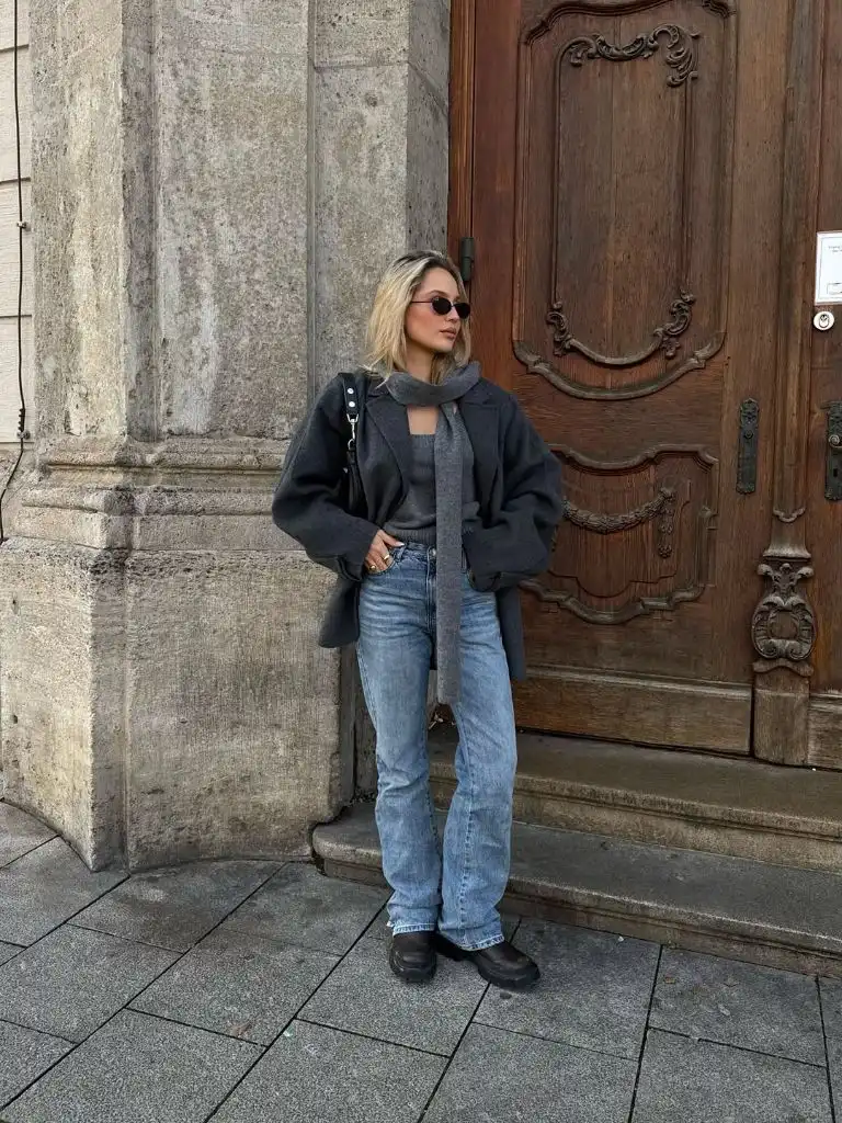 Charcoal grey oversized wool jacket with cashmere scarf, light-wash jeans, and chunky black boots