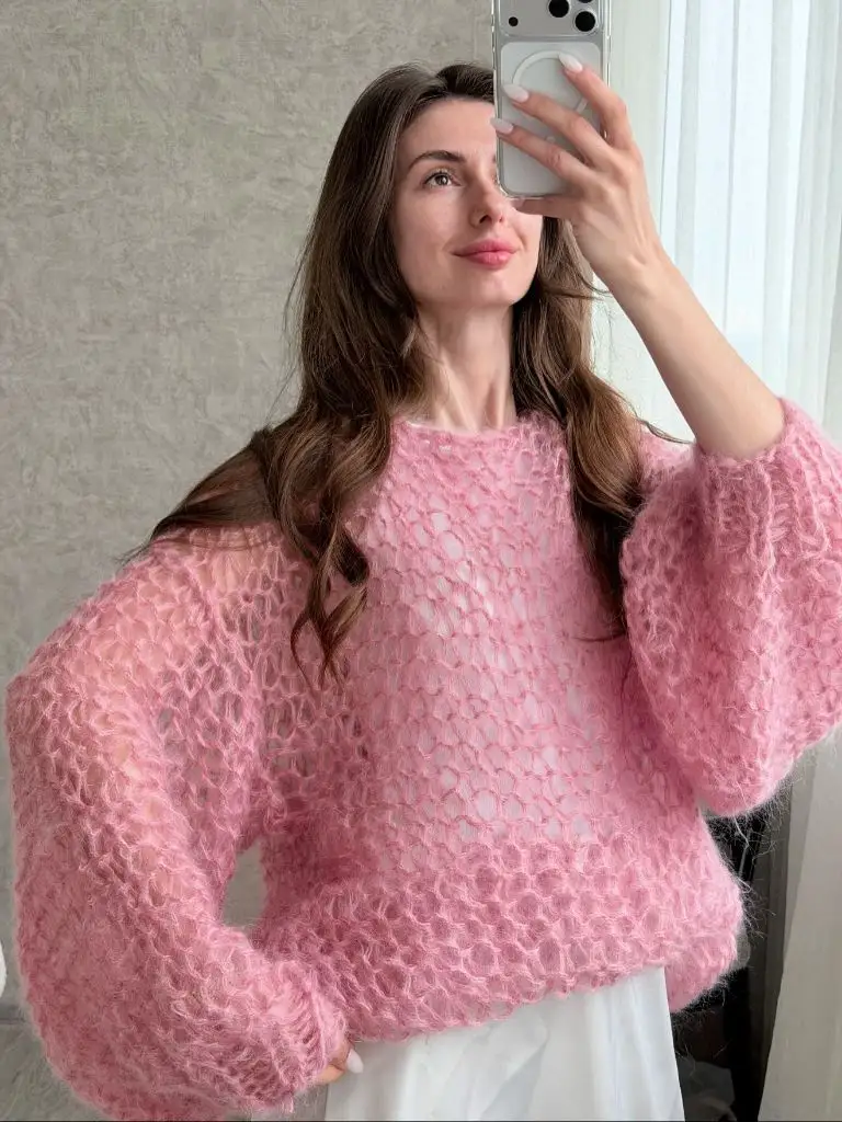 Pink open-weave mohair sweater with white trousers