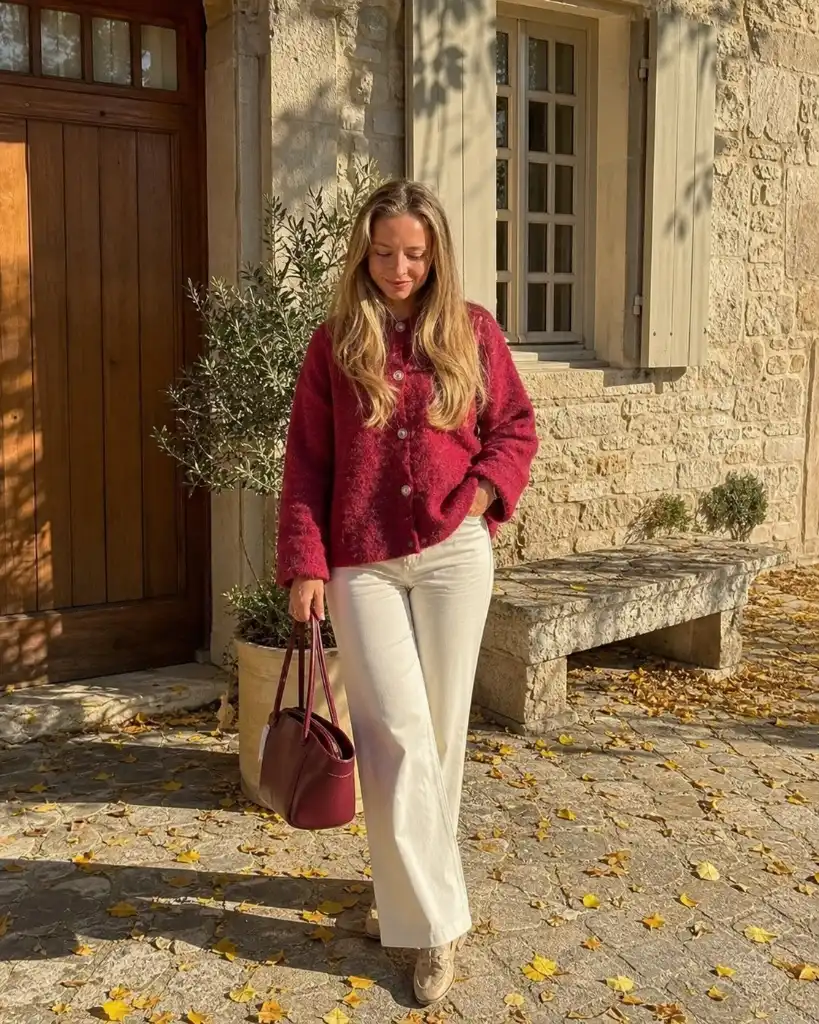Red/raspberry cardigan with white wide-leg jeans and burgundy bag