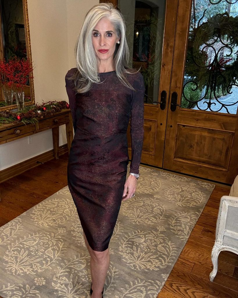 Deep burgundy long-sleeve fitted midi dress in a festive interior
