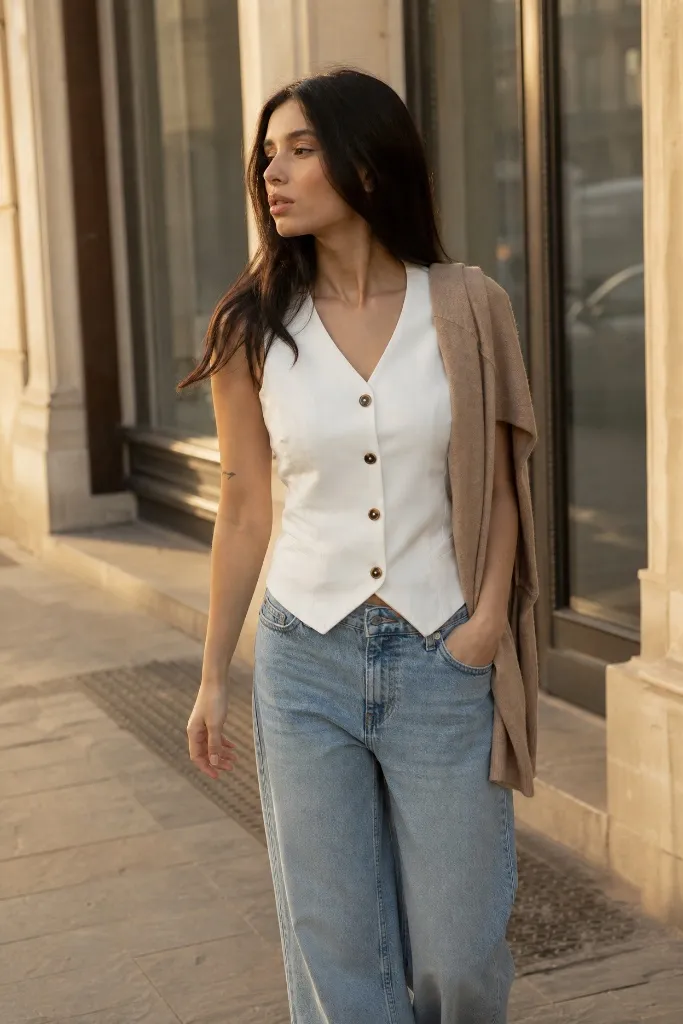 White button-front waistcoat with wide-leg blue jeans and draped cardigan