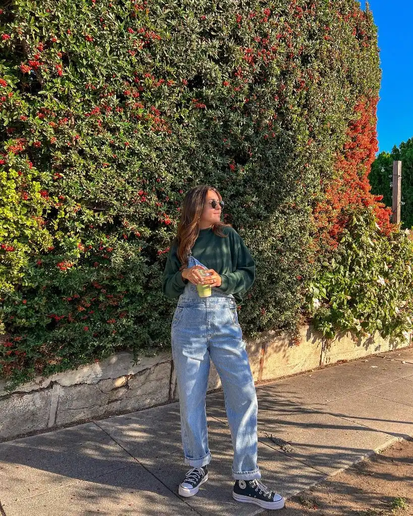 Olive green sweatshirt with light jeans and Converse