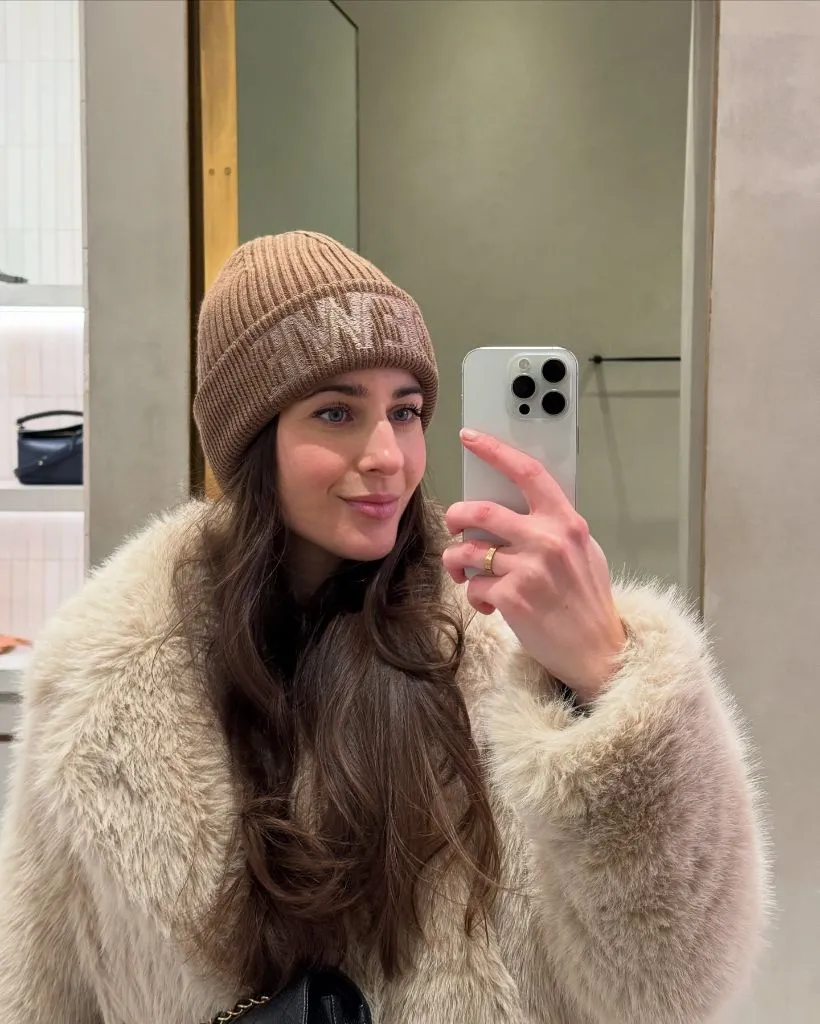 Cream faux fur jacket with branded beanie selfie
