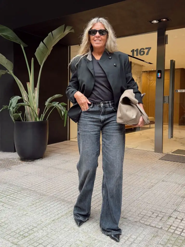 Black blazer over black tee with charcoal wide-leg jeans and gray bag
