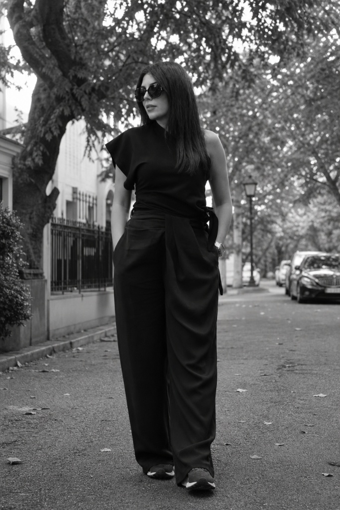 Black and white photo of all-black outfit with asymmetric top and wide-leg trousers