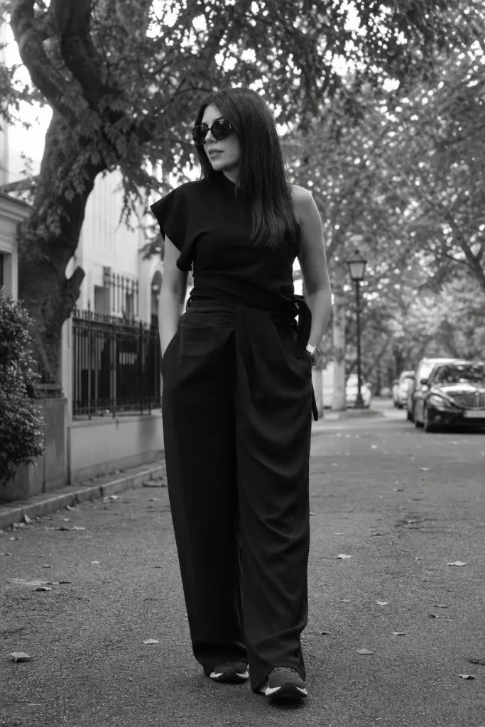 Black and white photo of all-black outfit with asymmetric top and wide-leg trousers