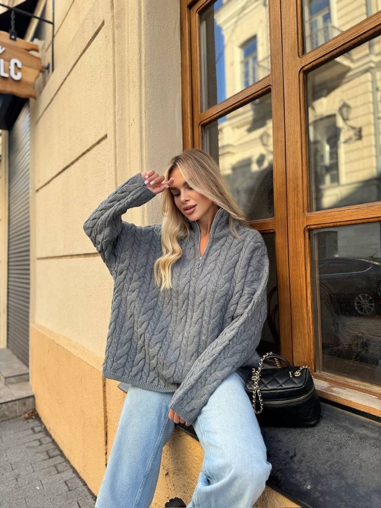 Grey cable-knit half-zip sweater with light wash jeans