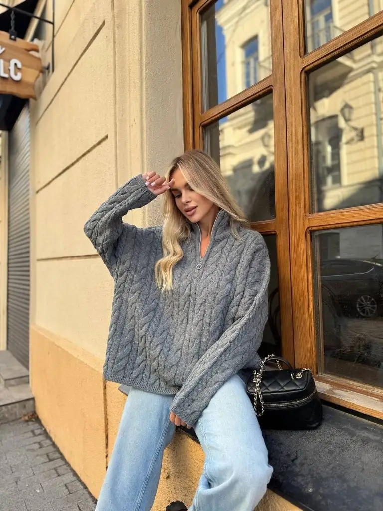 Grey cable-knit half-zip sweater with light wash jeans