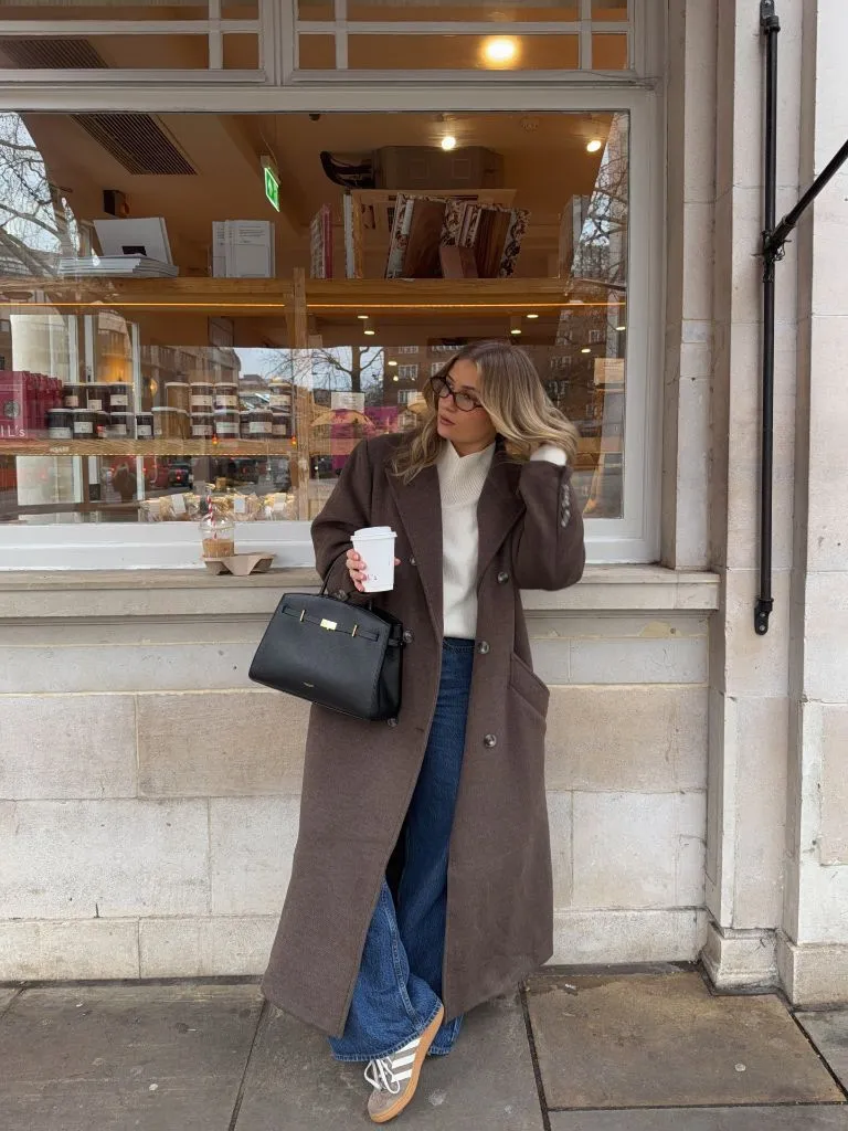 Brown coat with white sweater and Adidas Sambas