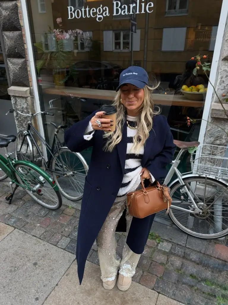 Navy coat with zebra sweater and sequin pants outside Bottega Barlie