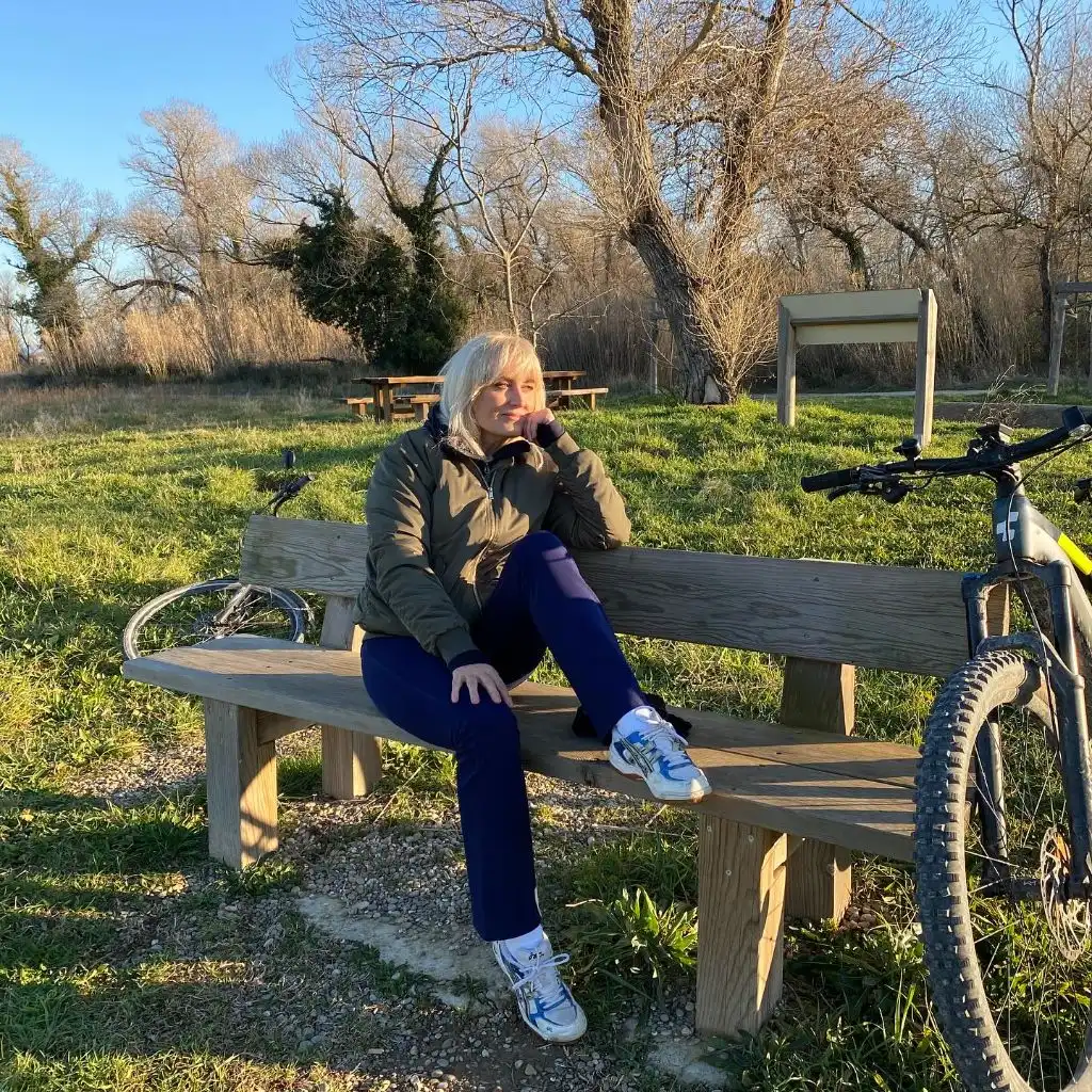 Olive bomber jacket with navy joggers and sneakers sitting on a bench