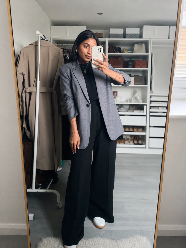 Grey pinstripe blazer with black wide-leg trousers and white sneakers