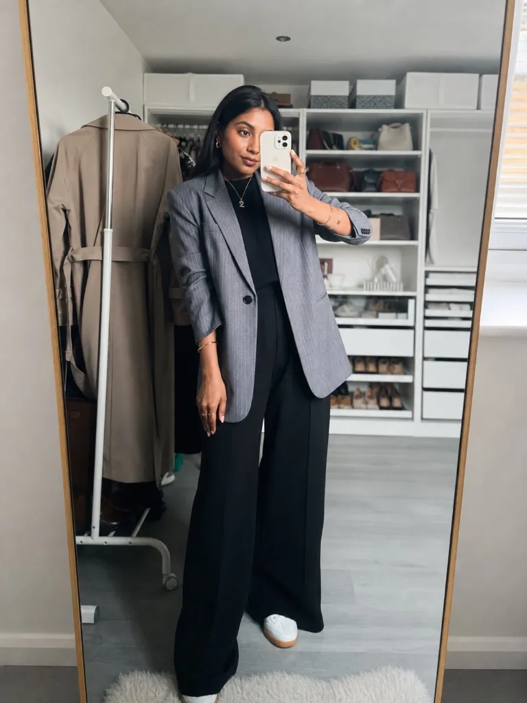 Grey pinstripe blazer with black wide-leg trousers and white sneakers