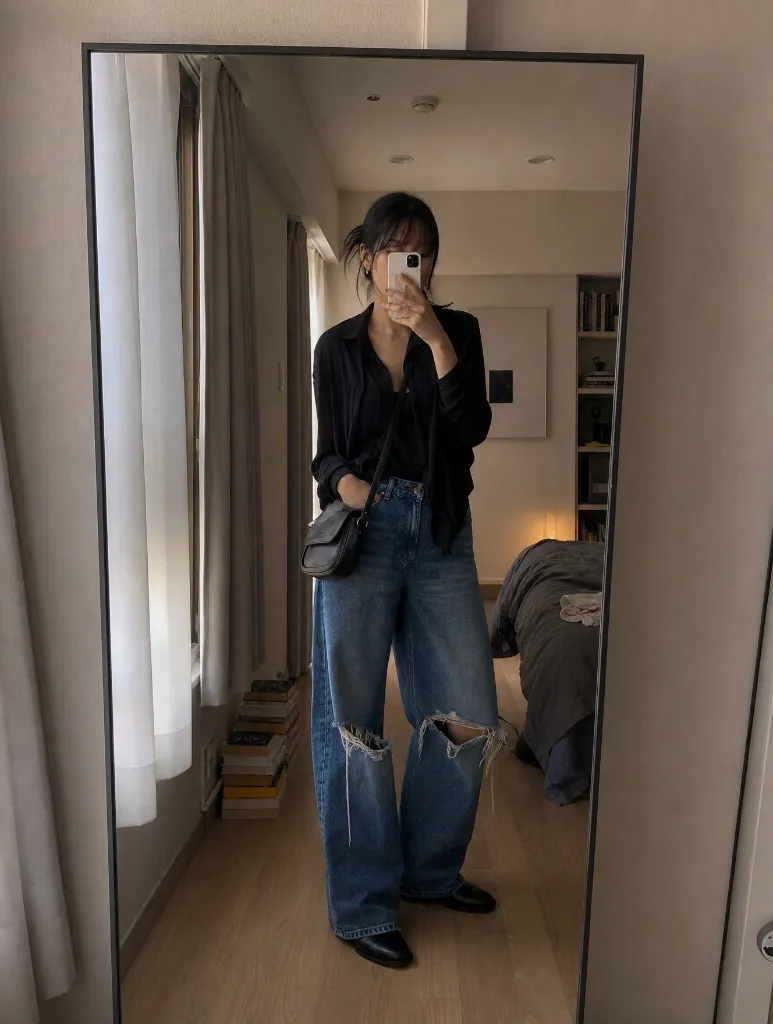Black button shirt with ripped wide leg jeans and black boots