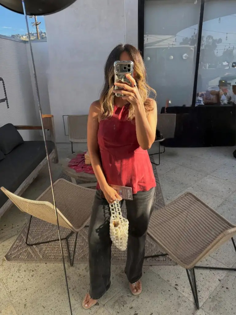 Red halter top with dark jeans and beaded bag
