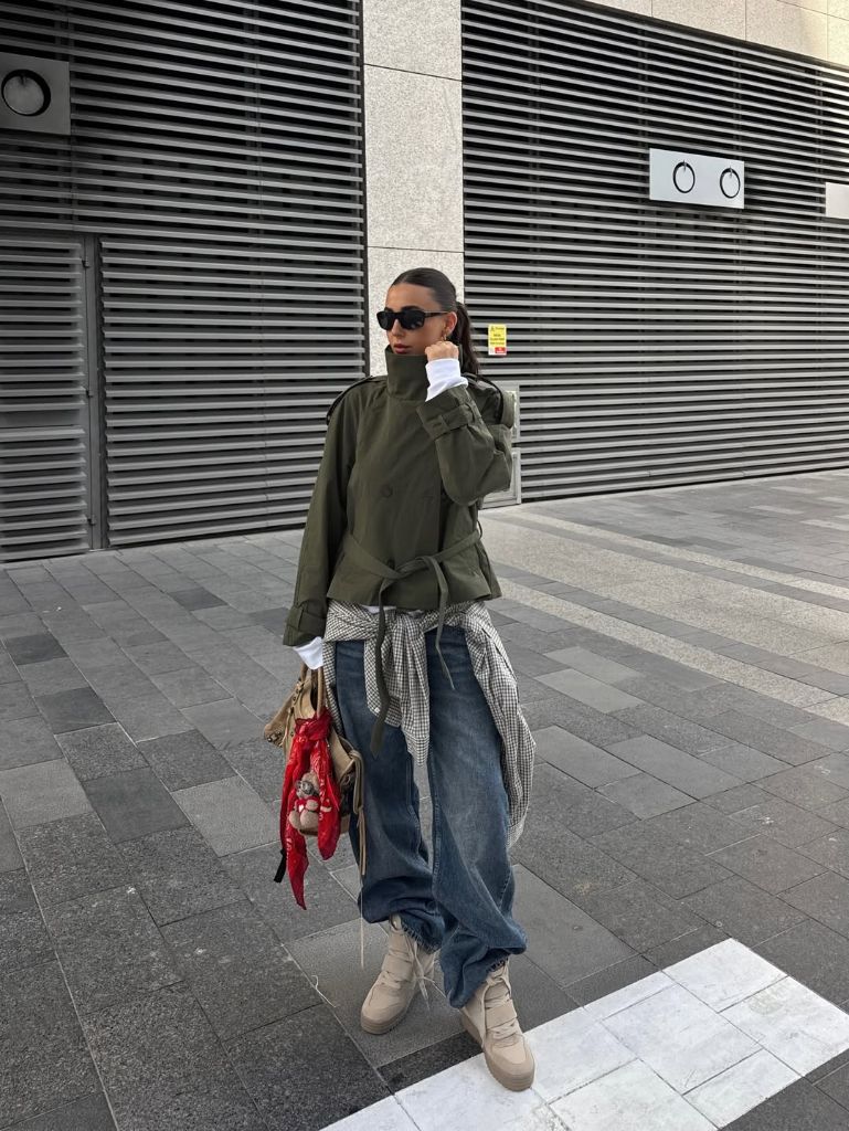 Olive green military jacket with wide-leg jeans, beige platform boots, and gingham shirt tied at waist