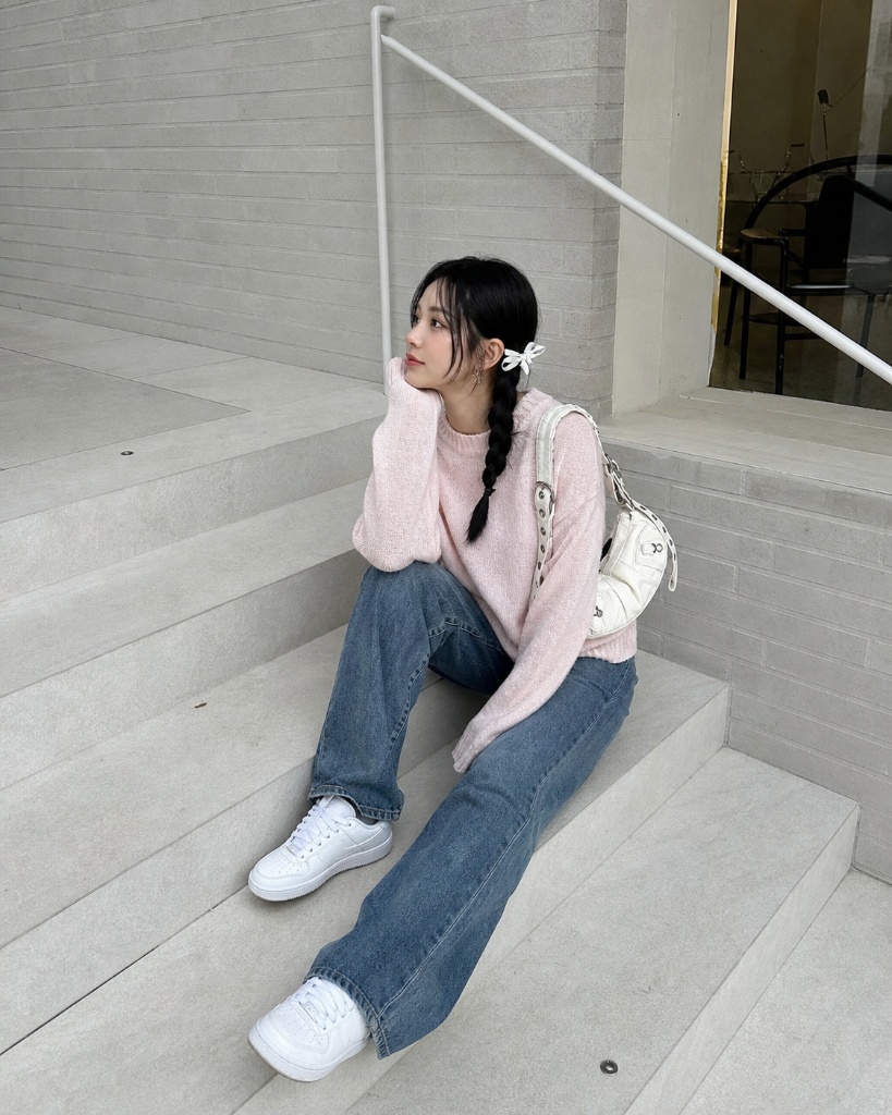 Pink sweater with jeans and white sneakers on steps