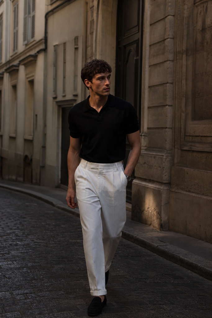 Fall outfit for men featuring black knit polo and cream wide-leg trousers