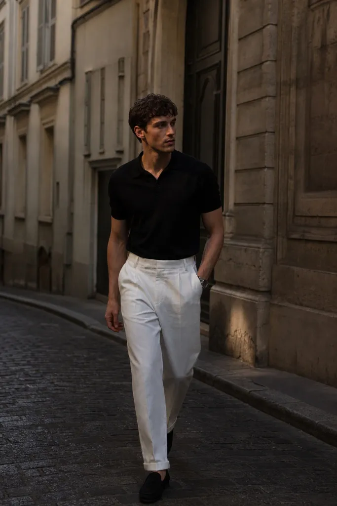 Fall outfit for men featuring black knit polo and cream wide-leg trousers