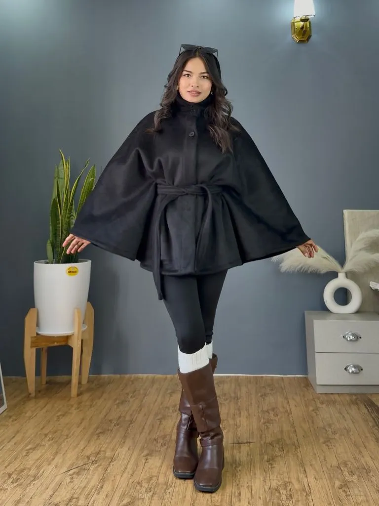 Black belted cape style coat with leggings and brown riding boots