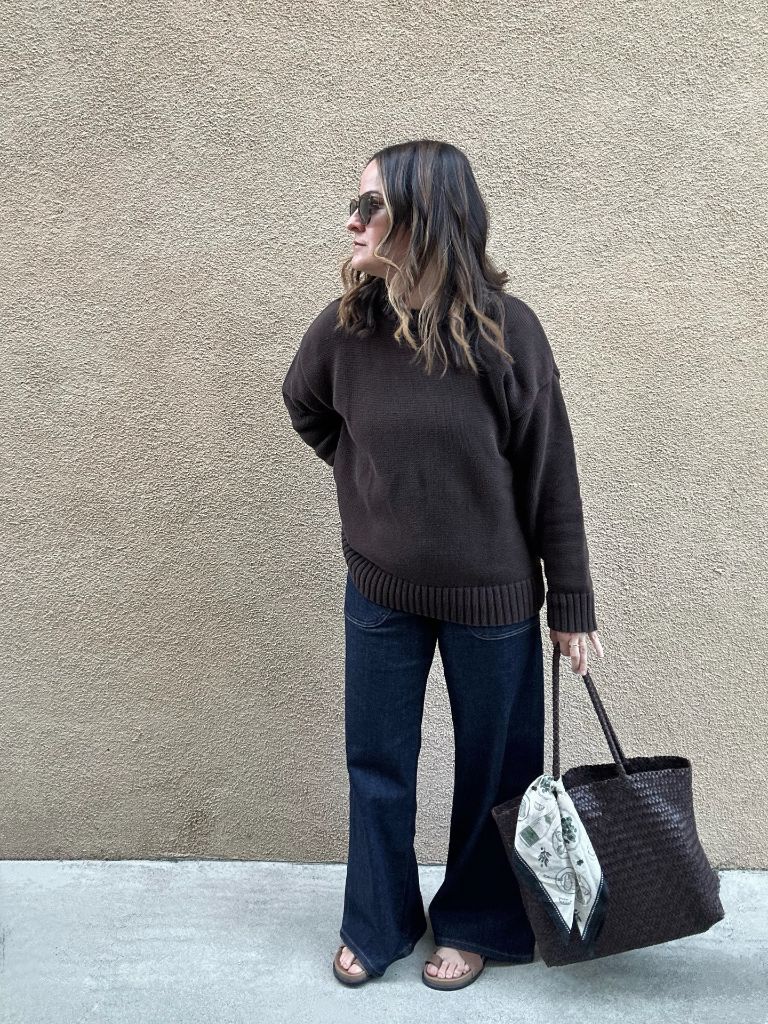 Fall professional outfit brown oversized sweater dark wide leg jeans woven tote sandals